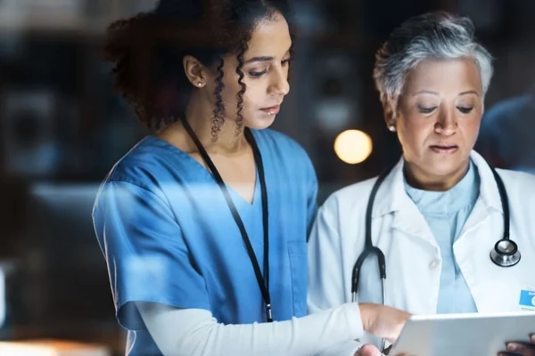 Duas médicas analisando dados no tablet