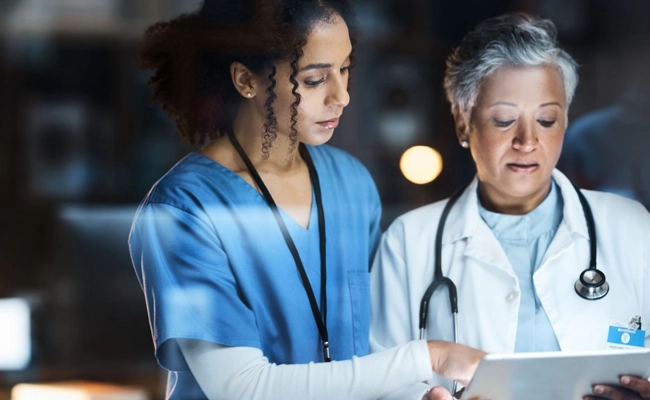 Duas médicas analisando dados no tablet
